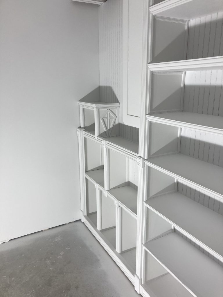 Early coats of spray finish on the bookcase and trim