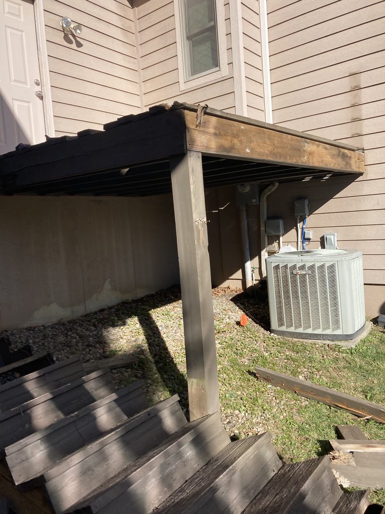 Old covered deck overhang above outdoor AC unit before repair