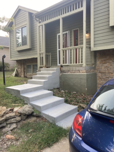 House exterior with new unrailed concrete steps leading to the front porch.