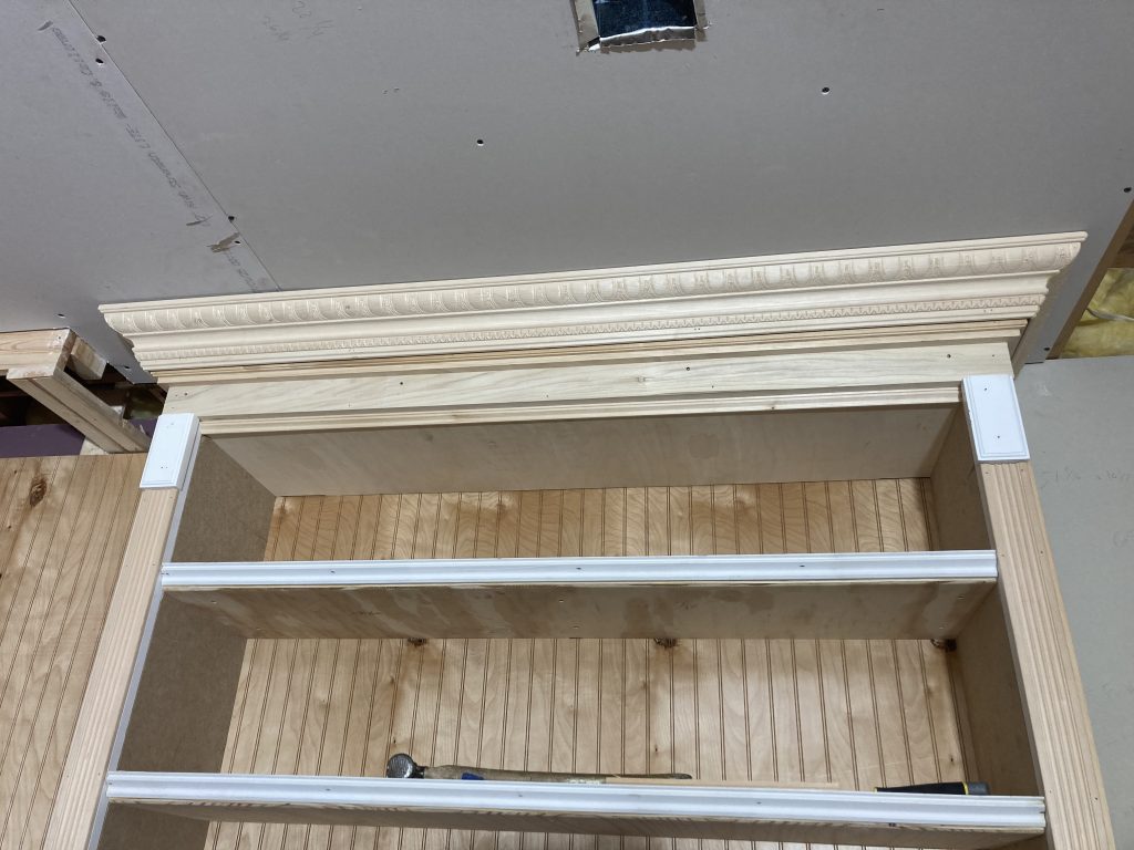 Crown moulding layered with additional profiles at the top of the built-in