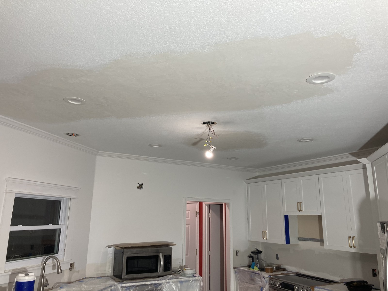Kitchen ceiling showing a patched texture area around round recessed light fixtures