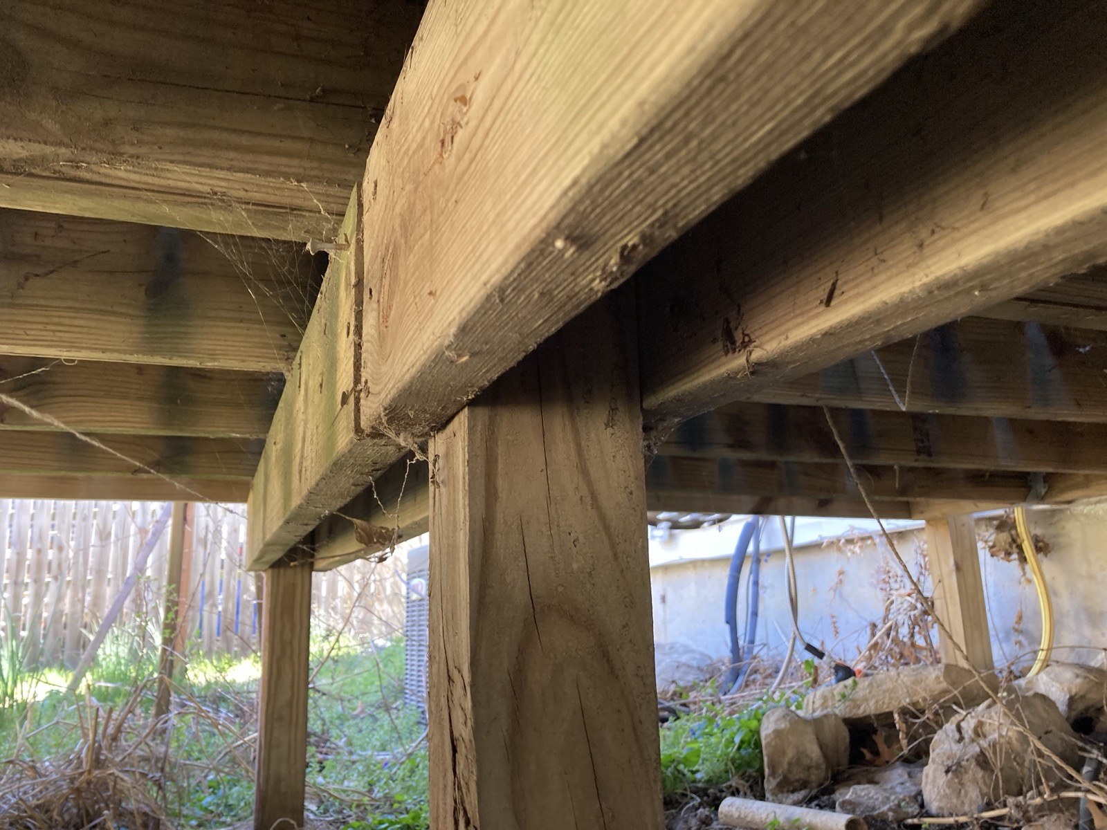 Close-up of a deck post and railing joint showing a split in the wood