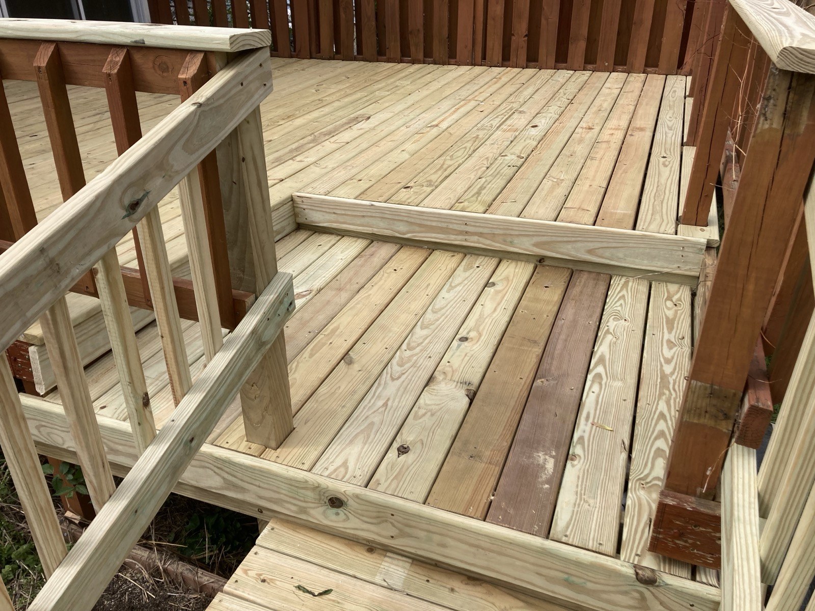 Close view of the finished deck surface and railing corner with new decking boards