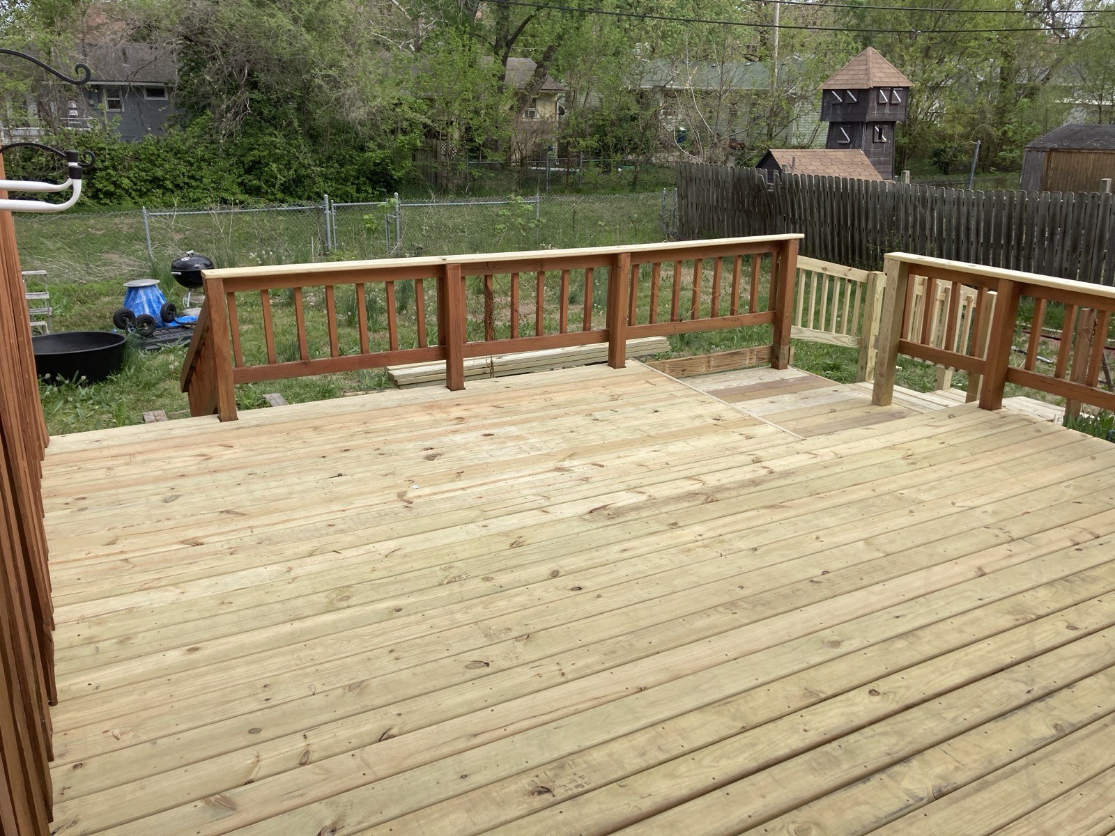 Finished deck surface and railing viewed toward the back of the yard