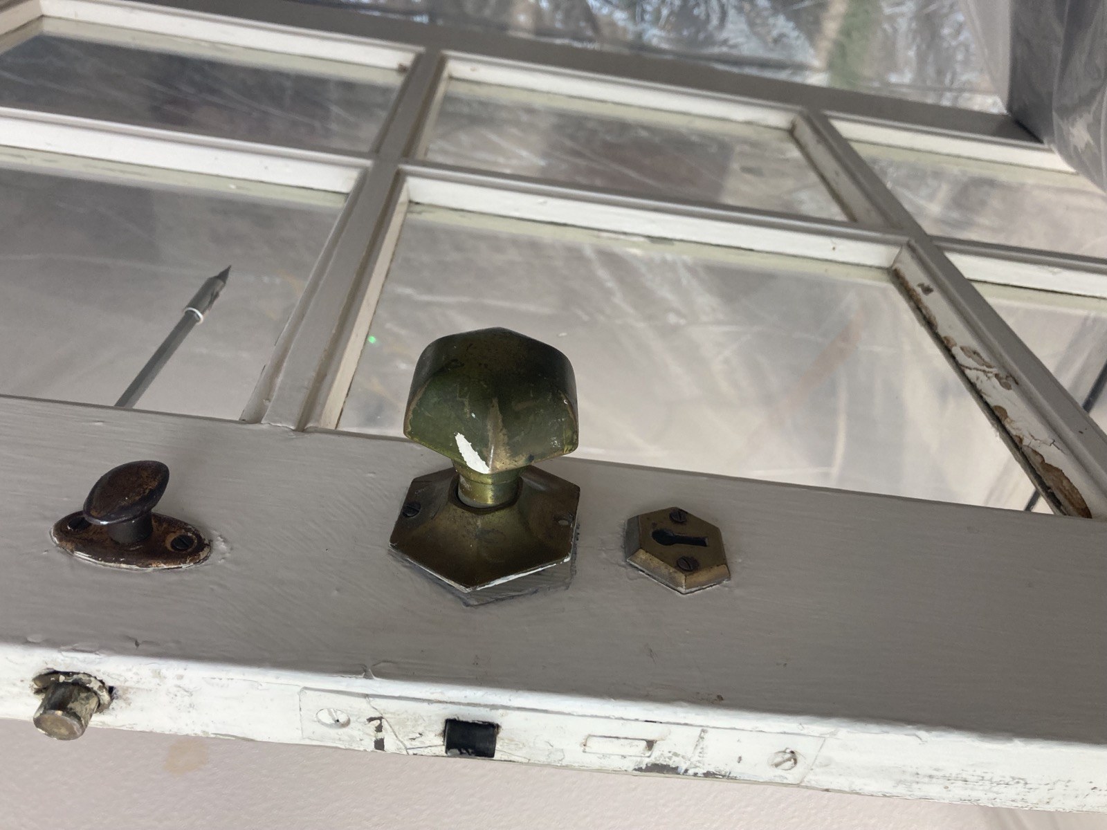 Original glass doorknob and backplate hardware before removal