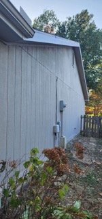 Completed rear wall with new siding repair and electrical panel visible
