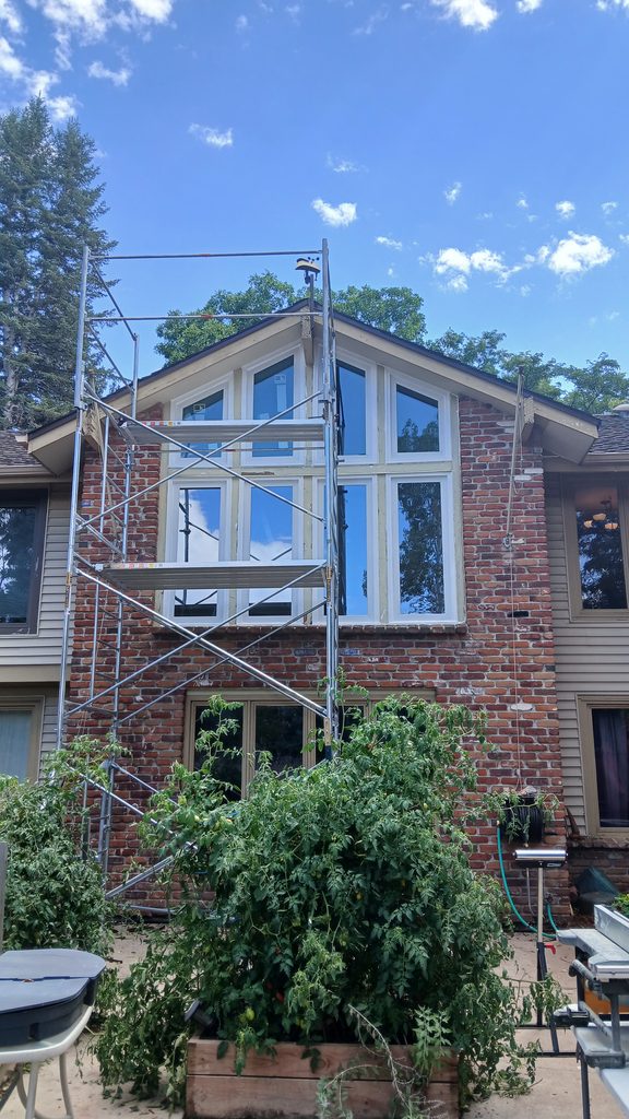 Full exterior view of the brick house with the finished window wall and new trim.
