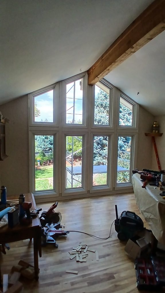 Interior view of the finished, primed window wall and casing with tools staged on a covered table.