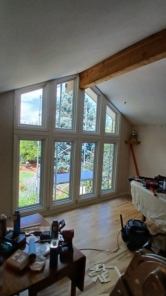 Full interior view of the completed primed window wall and casing with tools staged on a table.