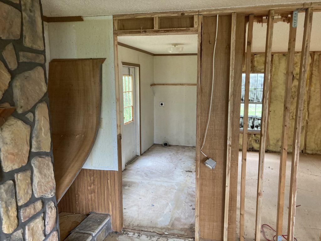 Narrow framed hallway with a water heater visible in an open utility closet.