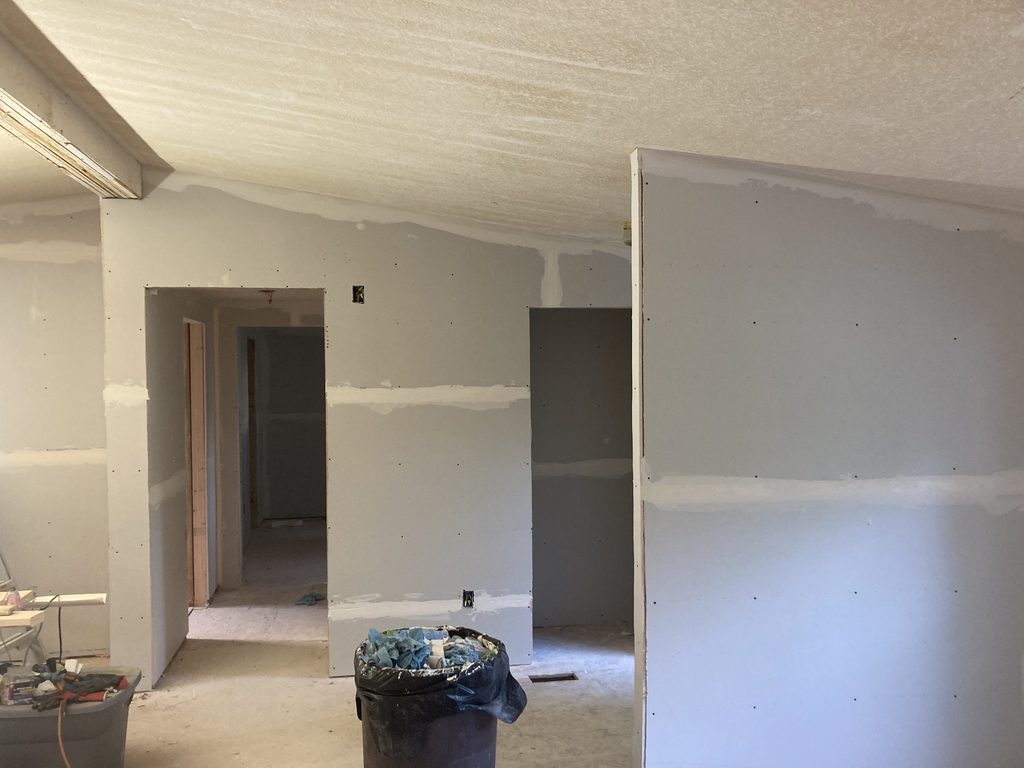 Finished drywall bedroom with open doorways leading to a hallway and closet.