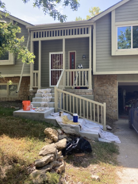 Front porch and steps with new painted railing, drop cloths still on site.