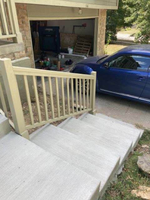 Finished painted railing running from the porch down to the driveway.