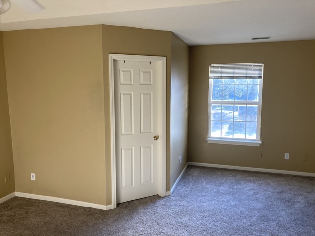 Bedroom wall and closet door with tan paint before the work began.