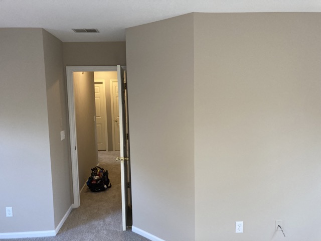 Bedroom closet corner with smooth, freshly painted walls after the repair.