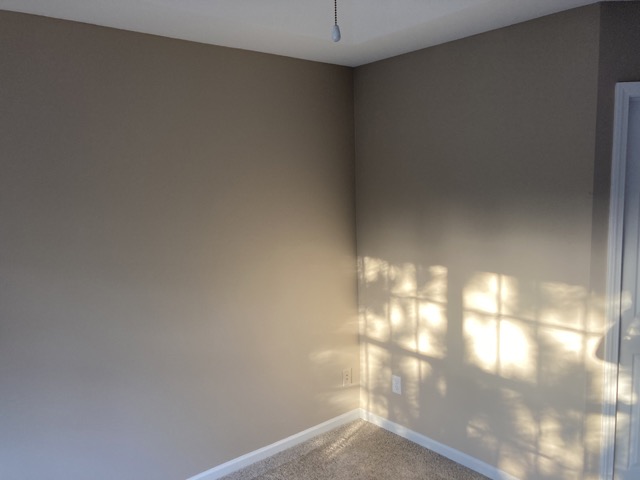 Close-up of a bedroom wall corner freshly painted with no visible patch marks.