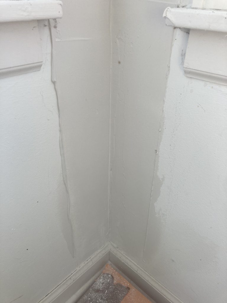 Freshly patched drywall corner and taped exterior door before final paint.