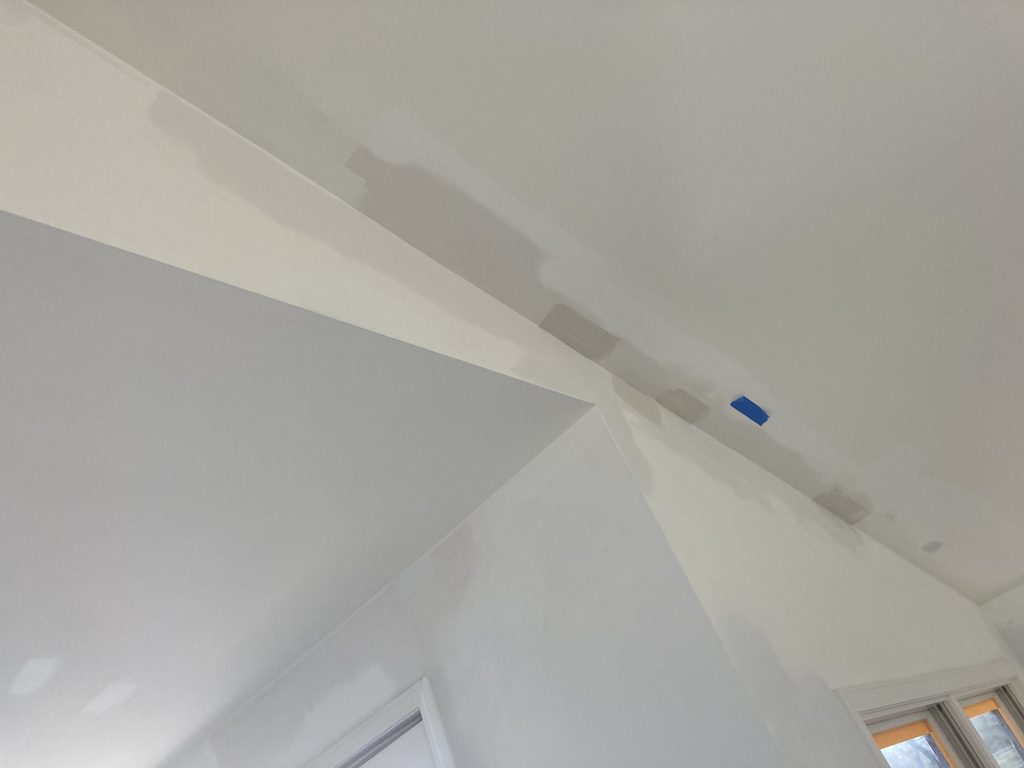 Patched drywall seams visible along a ceiling corner before texture and paint.