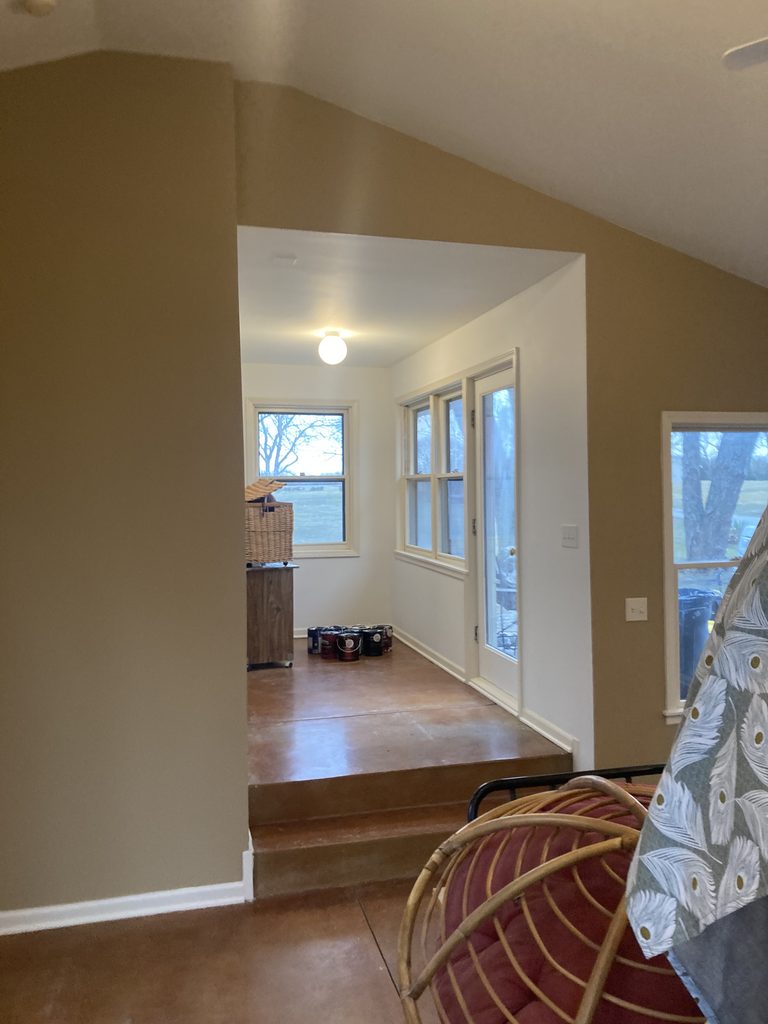 Finished sunroom hallway with windows and a door to the deck after the paint work.