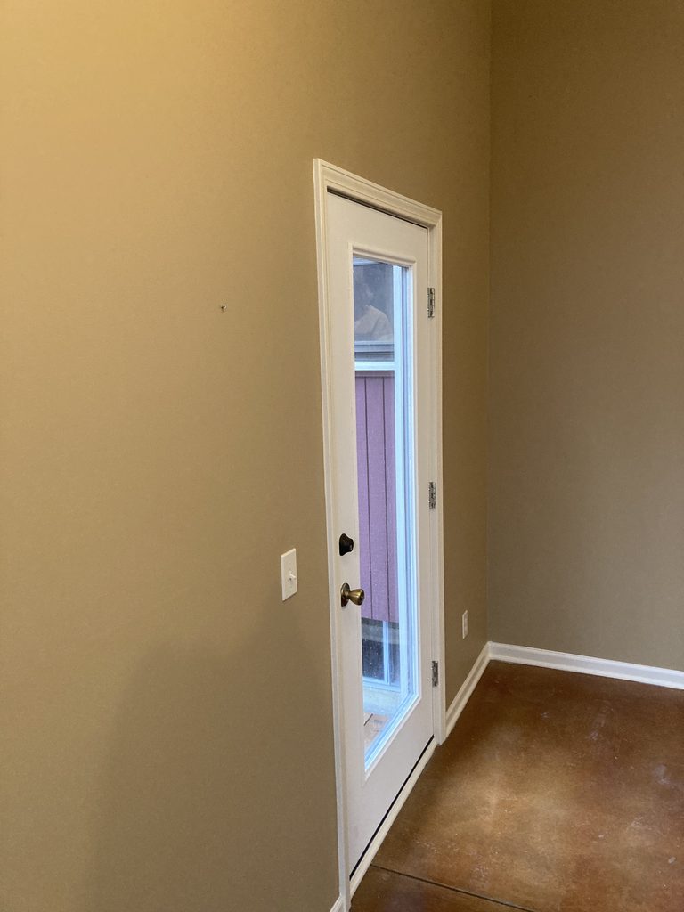 Finished white door and trim in the freshly painted sunroom.