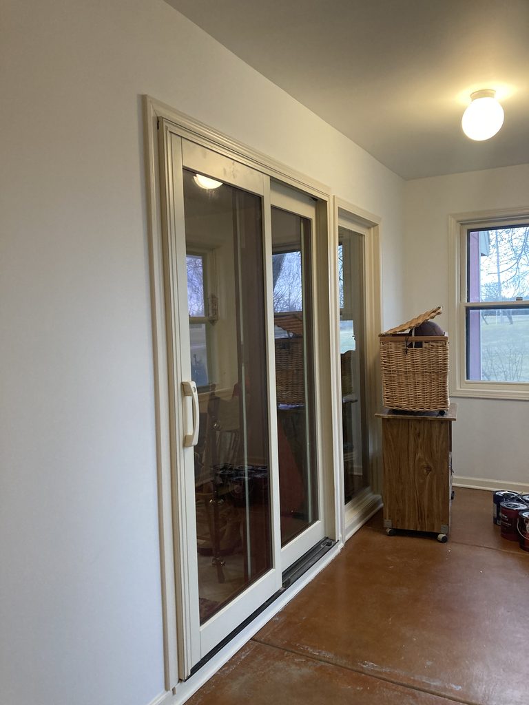 Finished sliding glass door and window trim in the repainted sunroom.