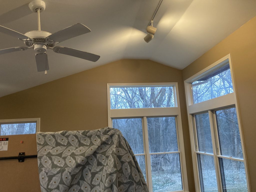 Finished vaulted ceiling with a ceiling fan and windows after the renewal.