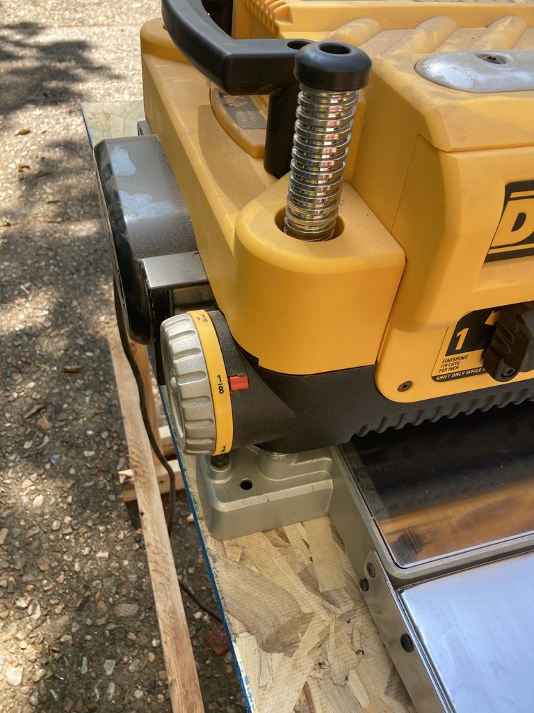 Close-up of a benchtop thickness planer's depth adjustment dial.