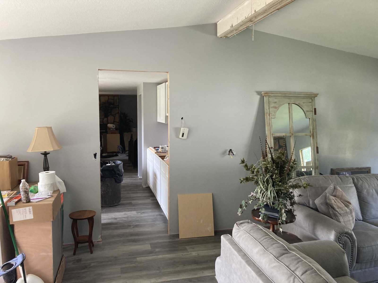 Finished living room with gray walls, vinyl plank flooring, and furniture moved in.