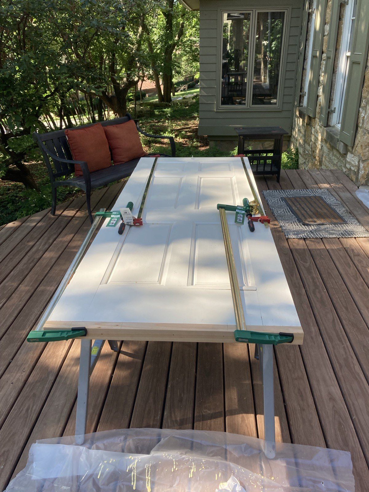 Restored panel door with first coat of white paint applied on sawhorses