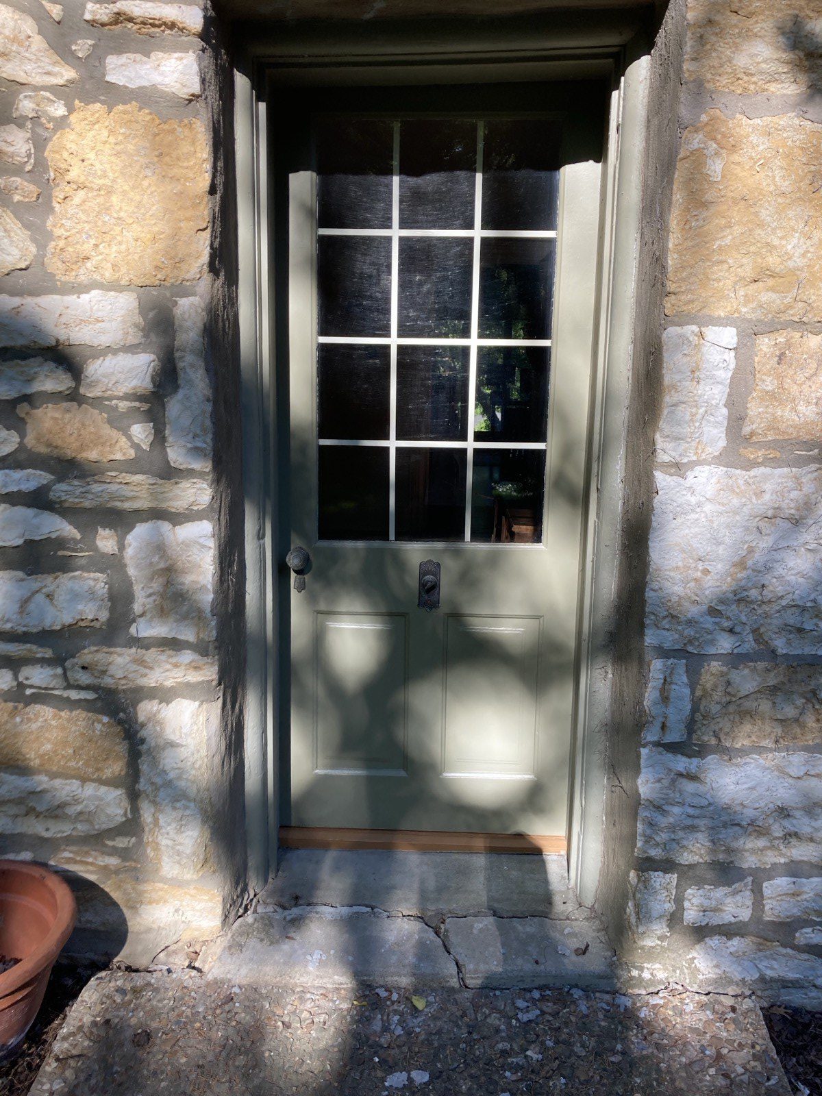 Twelve-light door in stone surround with reinstated original period knob hardware