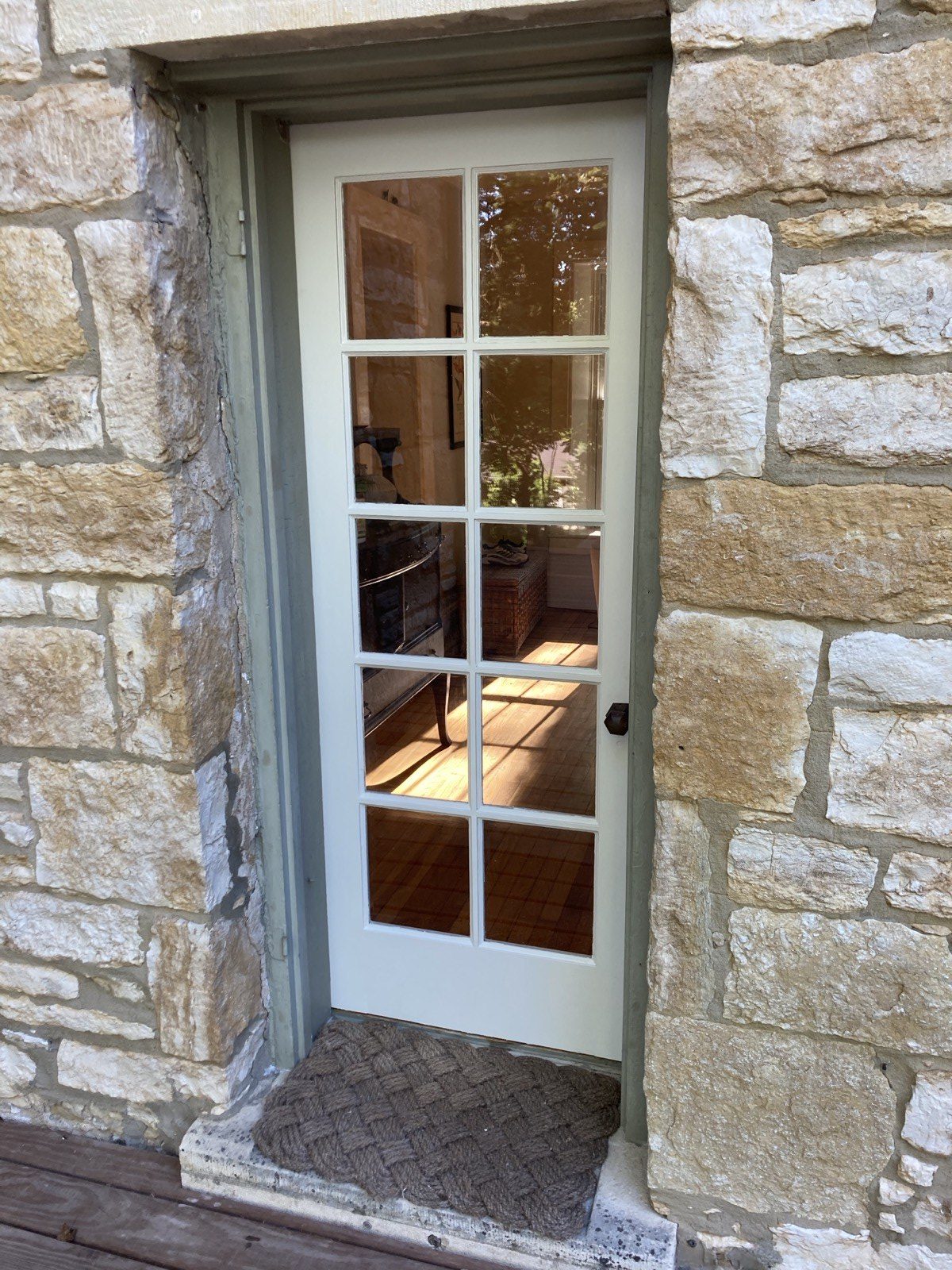 Restored ten-light transom window in stone surround with fresh paint and re-glazed glass